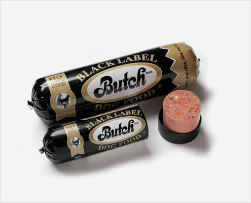 Two black-label Butch dog food sausages on a white background, one opened to reveal pink, textured interior.