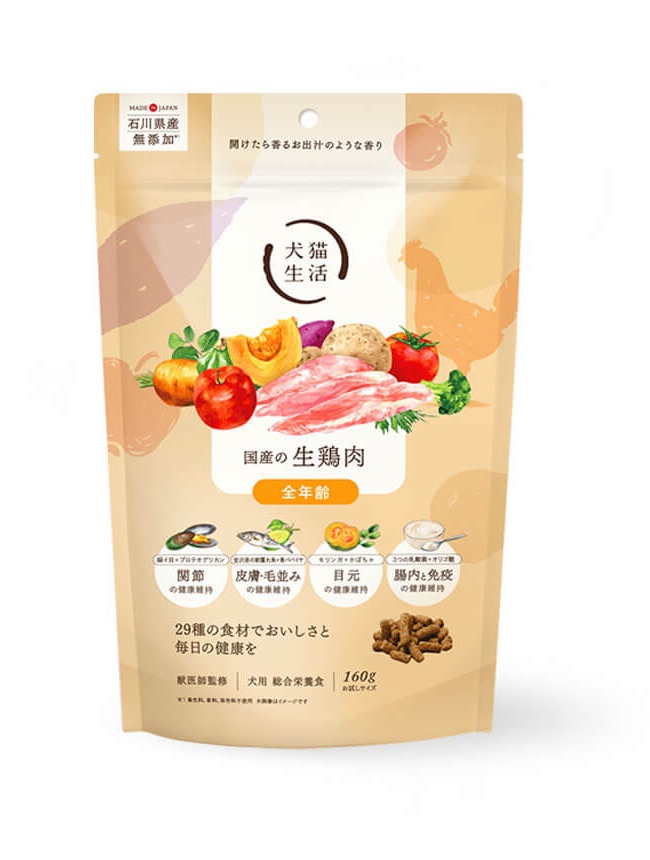 Beige dog food package with colorful vegetables and chicken pieces on the front, Japanese text and logo visible.